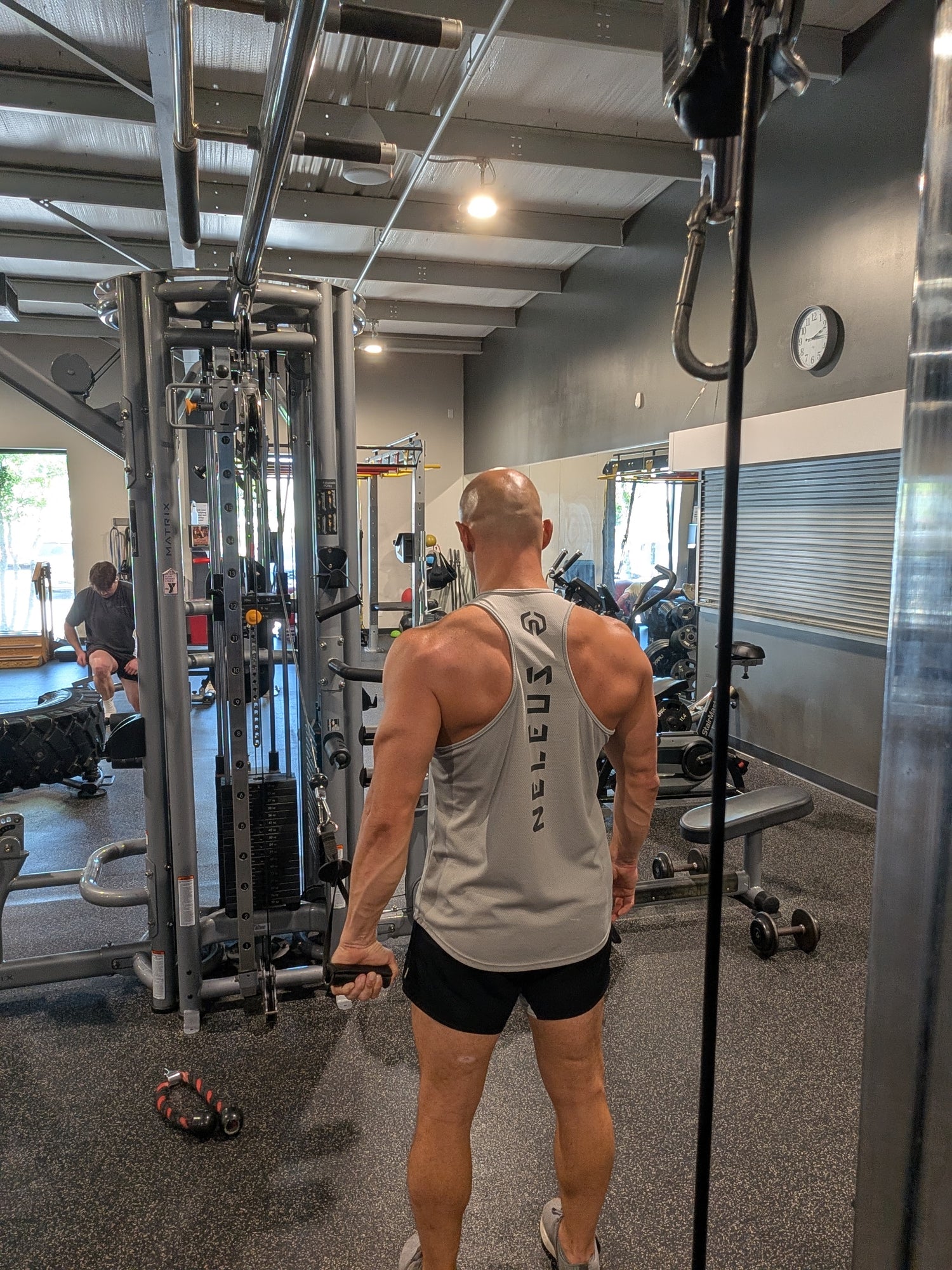 Mathieu Lesgourgues performing cable single-arm lat pulldown exercise in gym
