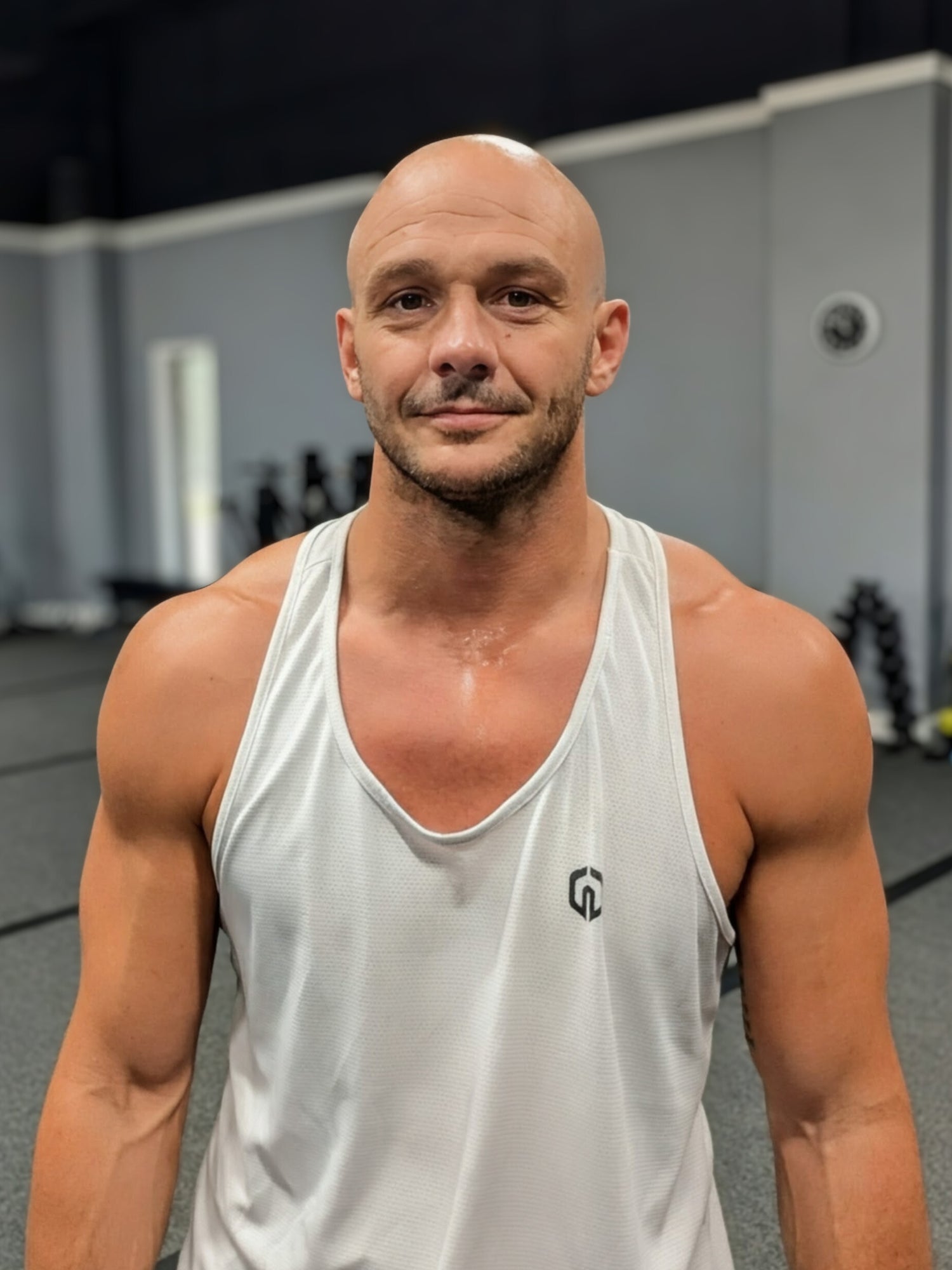Mathieu Lesgourgues, Peak founder and coach, in gym wearing white tank top