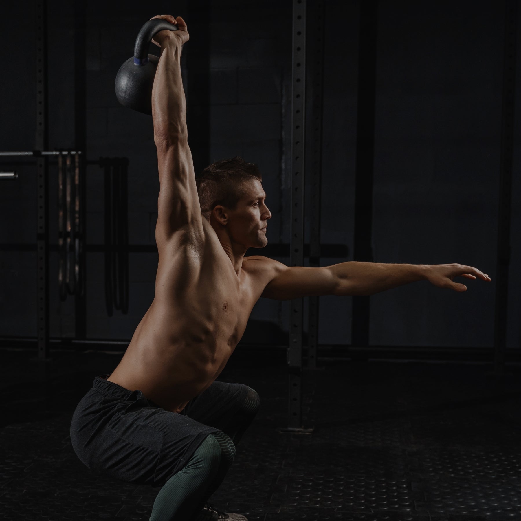 Man lifting a kettlebell in a gym setting