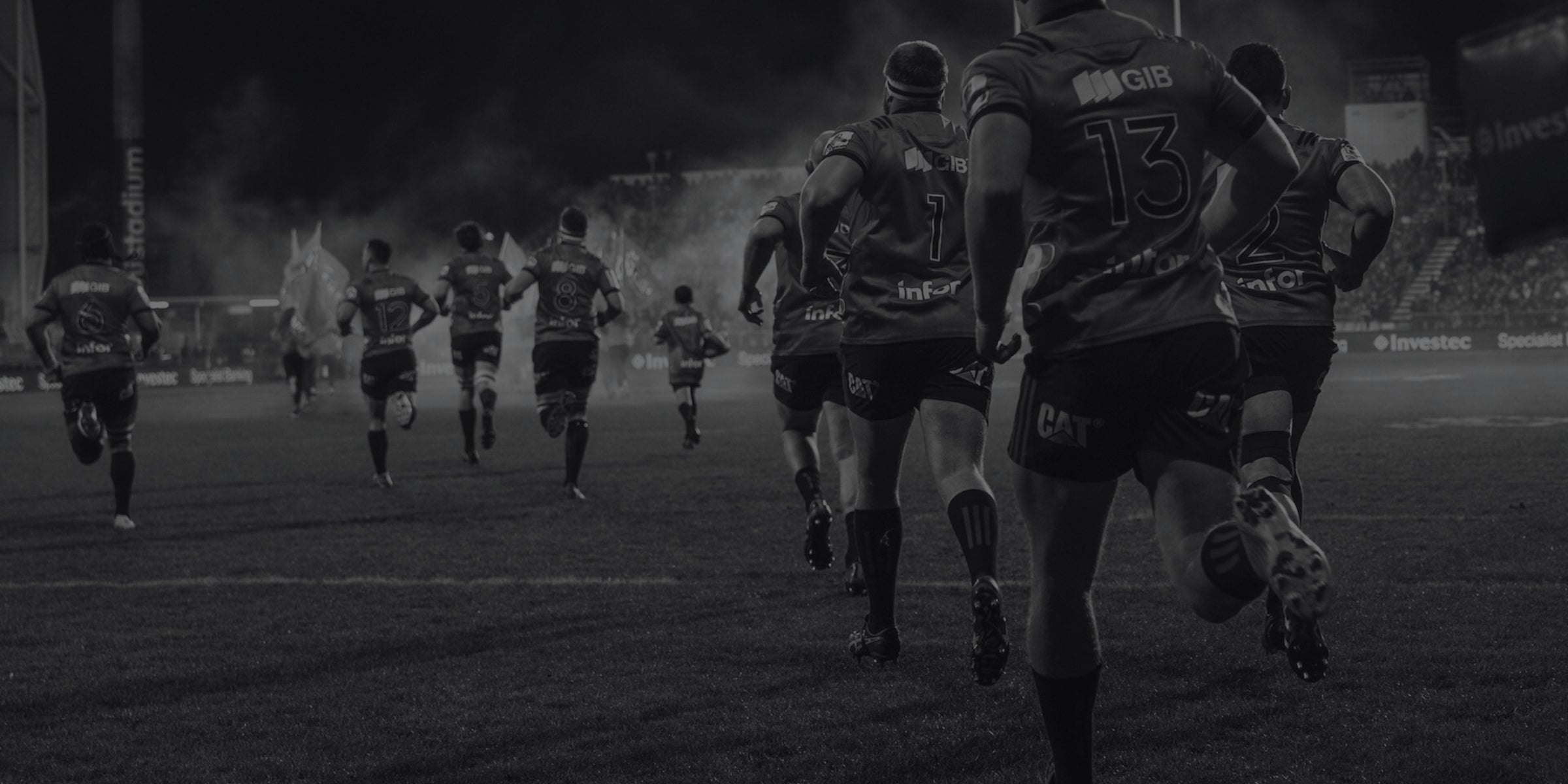 Rugby players running on a field with a dark, moody atmosphere