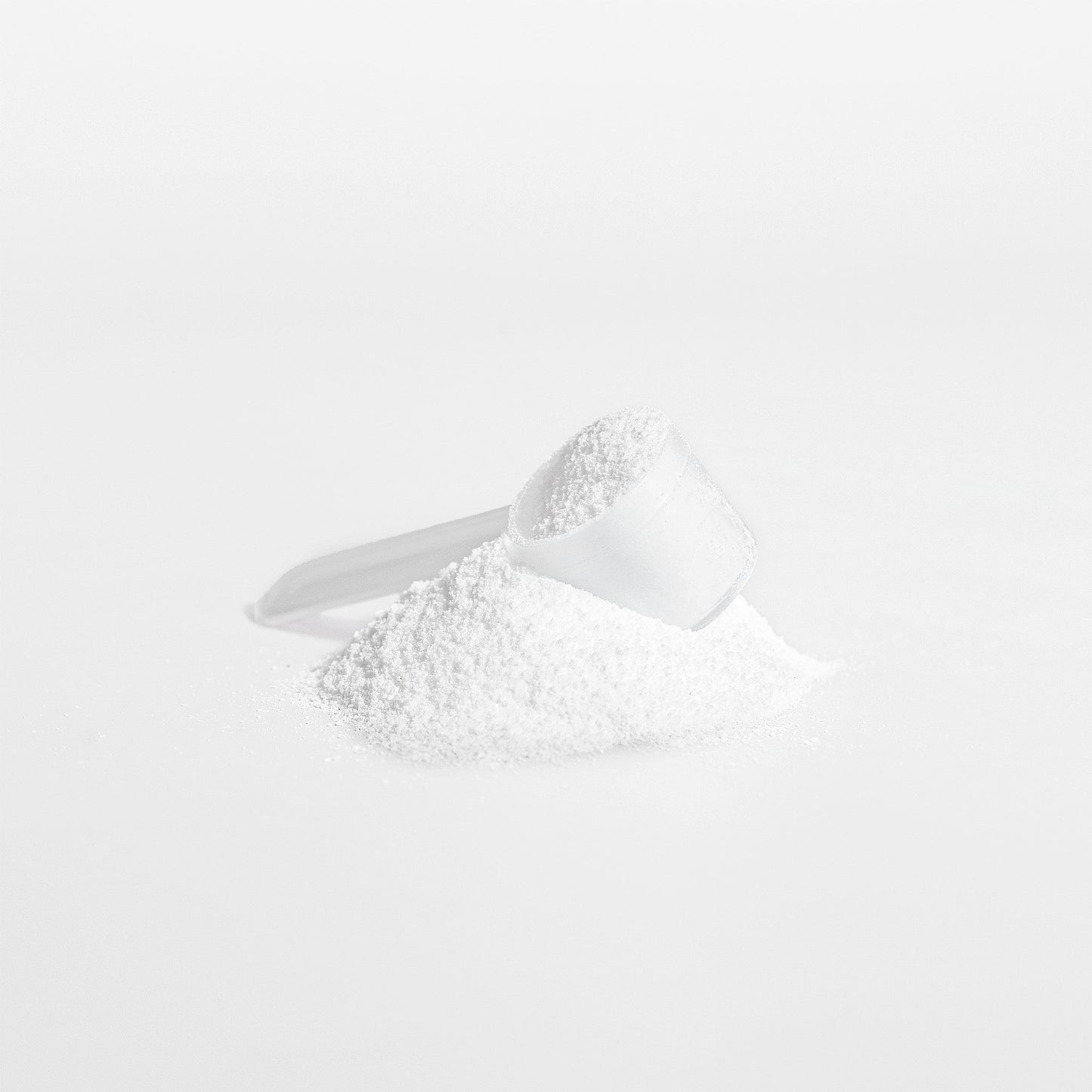 White powder in a measuring spoon on a white background